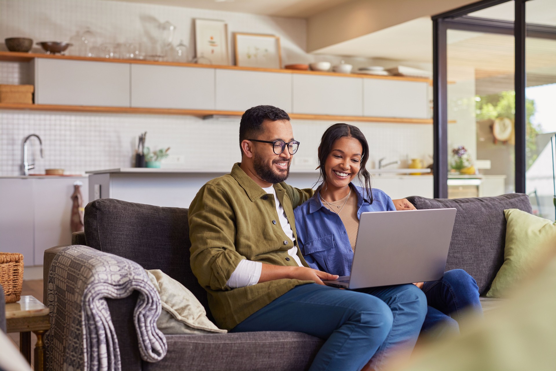 Multiethnic couple using laptop at home